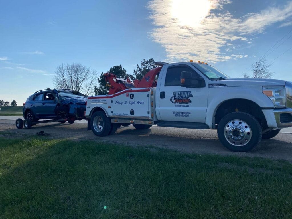White towing truck towing black car